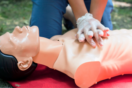 Person practicing CPR on a dummy