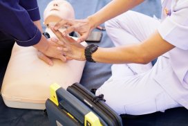 Basic life support instructor teaches how to pump a heart on silicone rubber dummy.
