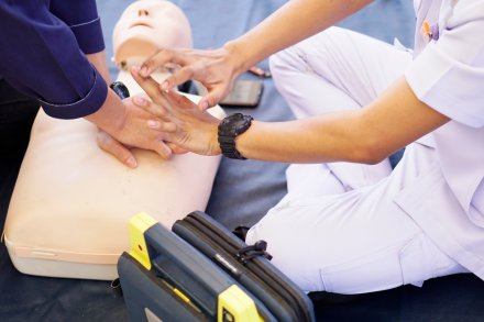 Basic life support instructor teaches how to pump a heart on silicone rubber dummy.